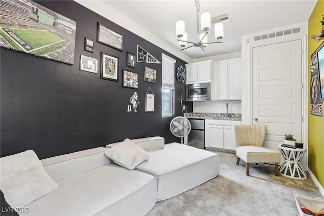 bedroom with a notable chandelier, light colored carpet, visible vents, a sink, and fridge