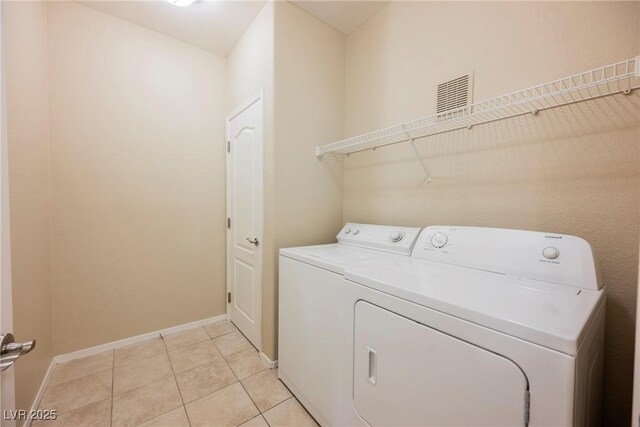 clothes washing area featuring independent washer and dryer and light tile patterned flooring