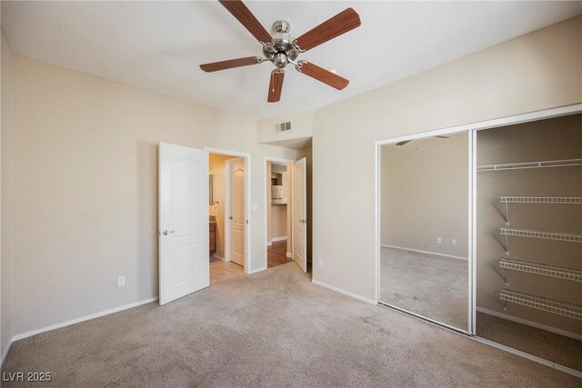 unfurnished bedroom with connected bathroom, light colored carpet, ceiling fan, and a closet