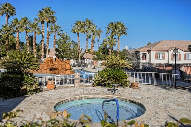 view of swimming pool featuring a hot tub