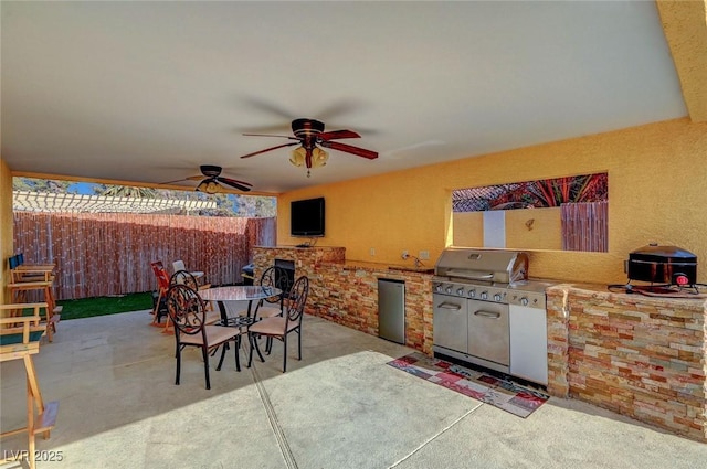 view of patio / terrace with ceiling fan and exterior kitchen