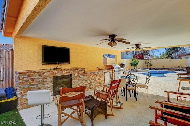 view of patio with a fenced in pool, a grill, and exterior kitchen