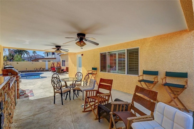 view of patio / terrace featuring ceiling fan and a fenced in pool