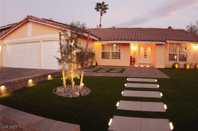 view of front of house with a garage and a lawn