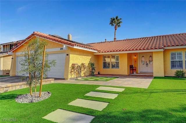 back of property with a garage and a lawn