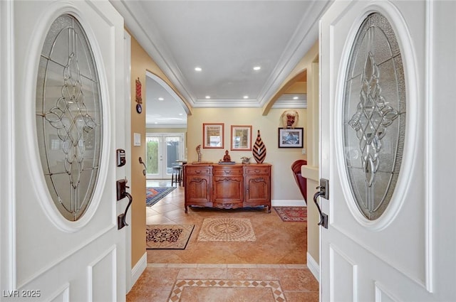 foyer entrance with light tile patterned floors, crown molding, and french doors