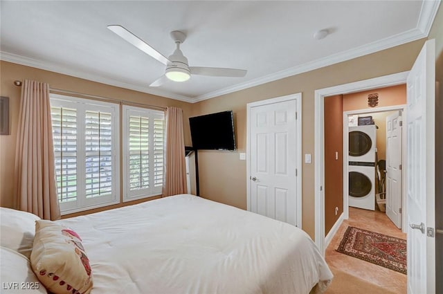 bedroom featuring stacked washing maching and dryer, ceiling fan, and crown molding