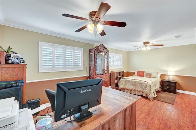 bedroom with hardwood / wood-style flooring, ornamental molding, and ceiling fan