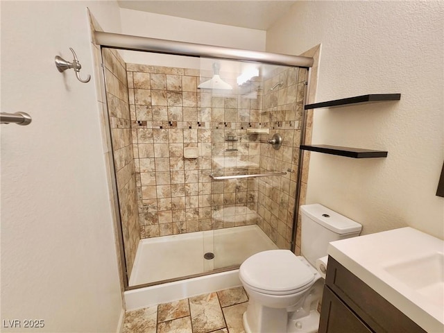 bathroom featuring vanity, toilet, and a shower with shower door