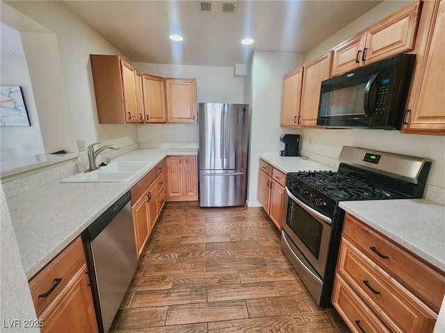 kitchen featuring sink, dark wood-type flooring, appliances with stainless steel finishes, light stone counters, and light brown cabinets