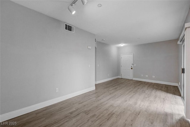 unfurnished room with rail lighting and light hardwood / wood-style floors