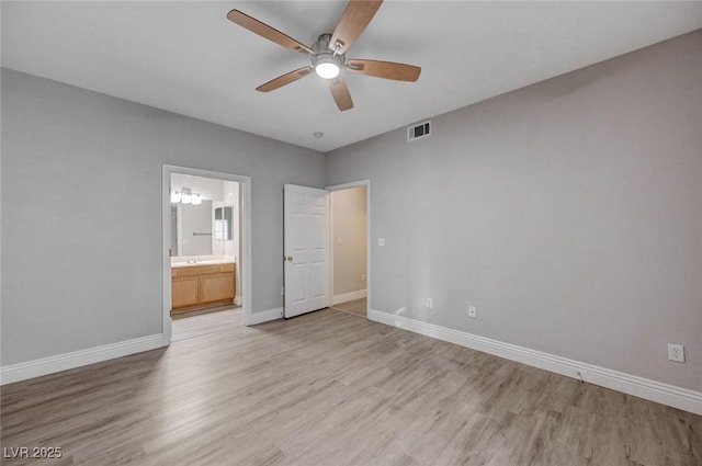 unfurnished bedroom with ceiling fan, ensuite bath, sink, and light wood-type flooring