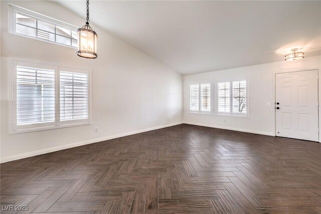 interior space featuring dark parquet flooring and high vaulted ceiling