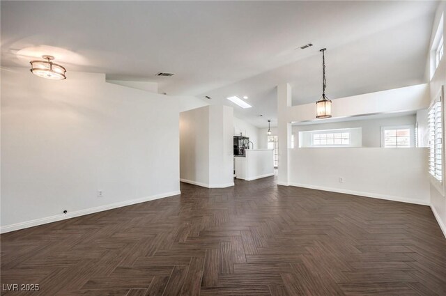 unfurnished living room featuring vaulted ceiling and dark parquet floors