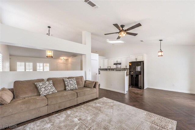 living room featuring vaulted ceiling, ceiling fan, and dark parquet floors