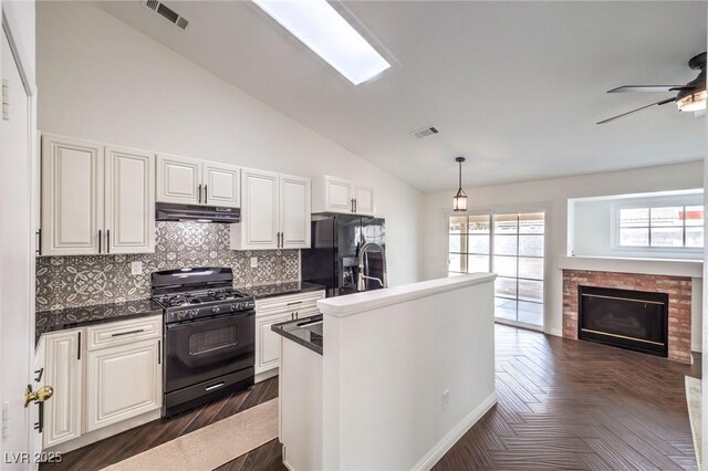 kitchen with vaulted ceiling, decorative light fixtures, white cabinets, backsplash, and black appliances