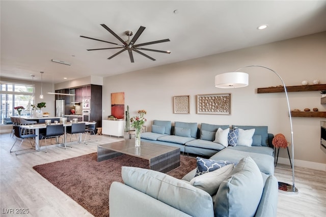 living room featuring ceiling fan and light wood-type flooring