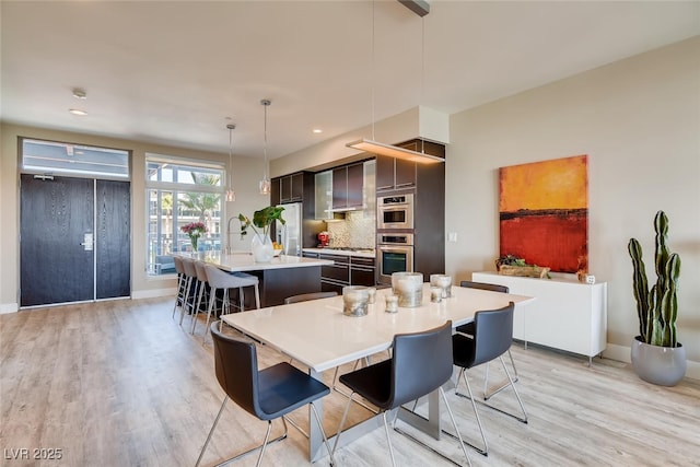 dining space with sink and light hardwood / wood-style flooring