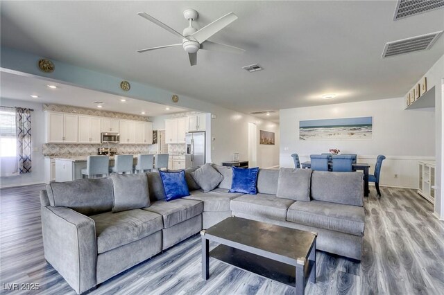 living room with ceiling fan and light hardwood / wood-style floors