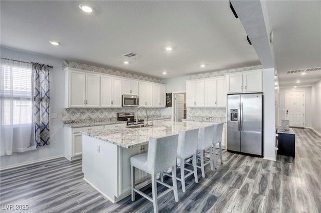 kitchen with visible vents, white cabinets, and stainless steel appliances