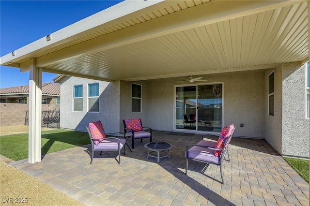 view of patio featuring a fire pit, ceiling fan, and fence