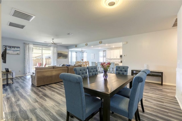 dining space with a wealth of natural light, visible vents, and wood finished floors