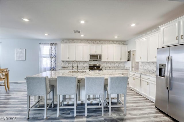 kitchen featuring white cabinetry, visible vents, appliances with stainless steel finishes, and a sink