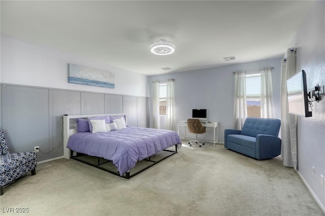 carpeted bedroom with visible vents and multiple windows