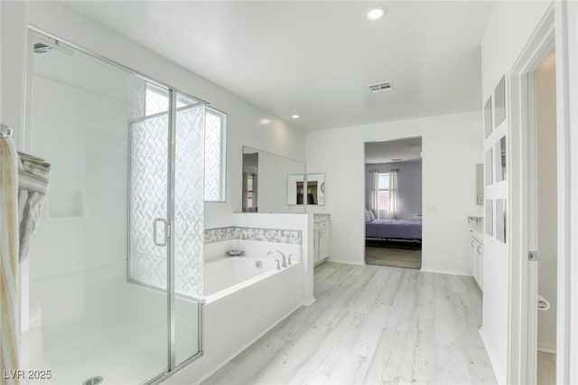 full bathroom featuring wood finished floors, visible vents, ensuite bath, a stall shower, and a bath