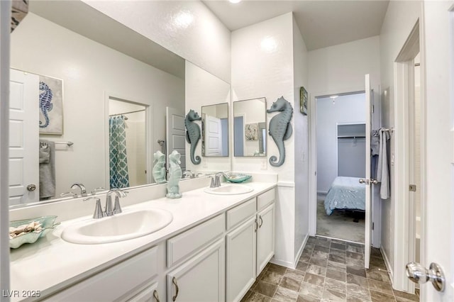 bathroom featuring a sink, stone finish flooring, a shower with curtain, and double vanity