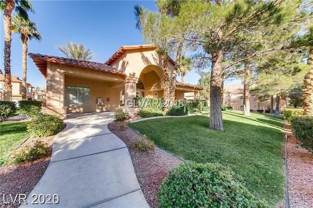 mediterranean / spanish home featuring a front lawn