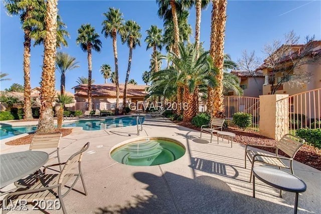 view of pool featuring a hot tub and a patio