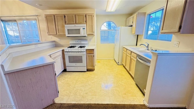 kitchen featuring white appliances, light brown cabinetry, and sink