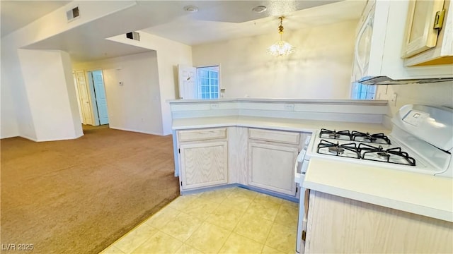 kitchen featuring decorative light fixtures, a chandelier, light carpet, kitchen peninsula, and white gas range oven