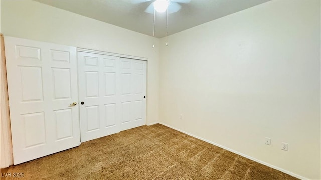 unfurnished bedroom with carpet, ceiling fan, and a closet