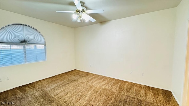 carpeted spare room featuring ceiling fan