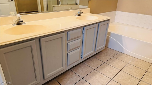 bathroom with a bathing tub, tile patterned floors, and vanity