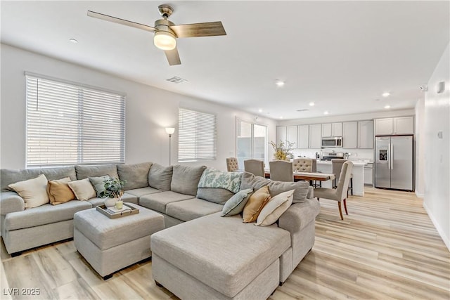 living room featuring light hardwood / wood-style floors and ceiling fan