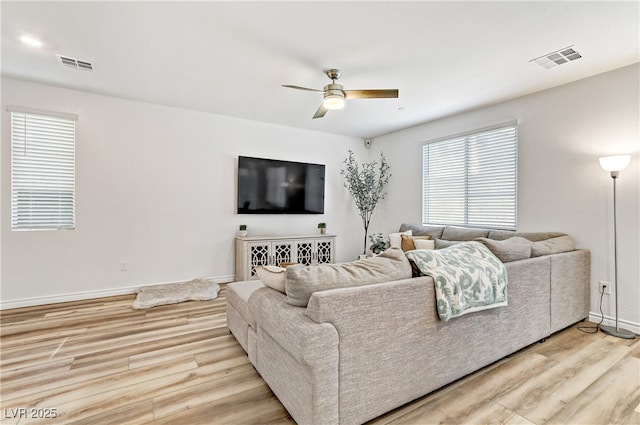 living room featuring ceiling fan and light hardwood / wood-style floors