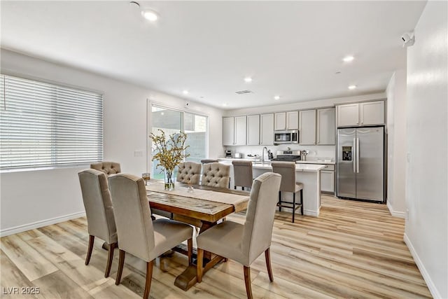 dining space with sink and light hardwood / wood-style floors