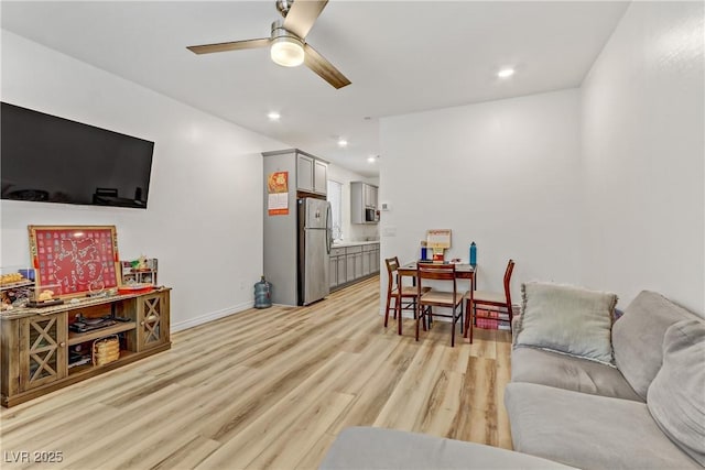 living room featuring ceiling fan and light hardwood / wood-style floors