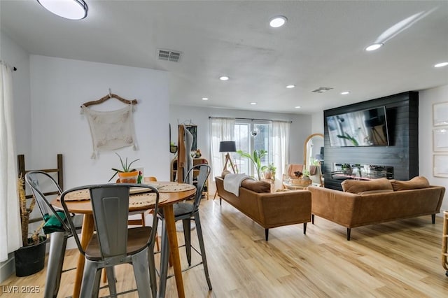 living room with a fireplace and light hardwood / wood-style flooring