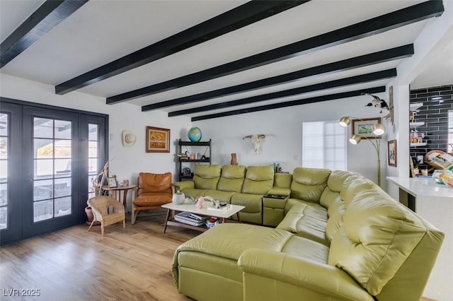 living room with french doors, beamed ceiling, and light wood-type flooring