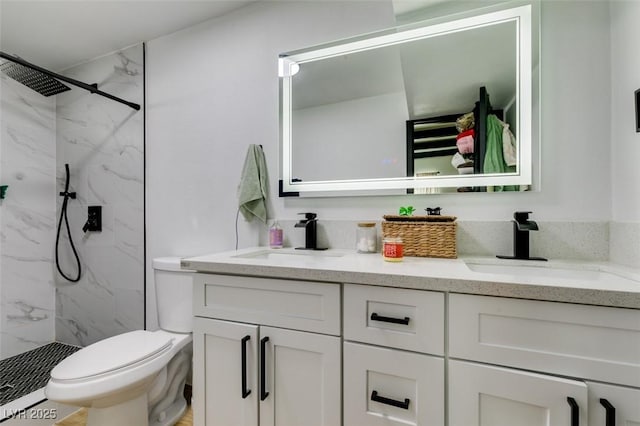 bathroom with vanity, tiled shower, and toilet