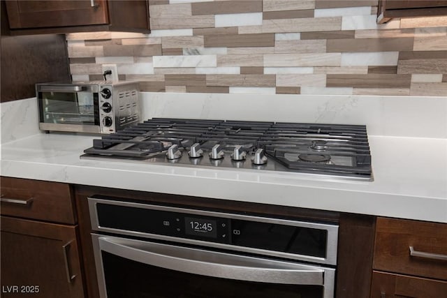 interior details with dark brown cabinetry, stainless steel appliances, and backsplash