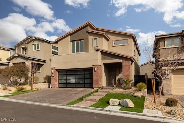 view of front of home featuring a garage, decorative driveway, and stucco siding