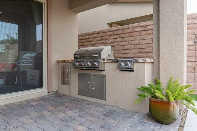 view of patio with area for grilling and a grill