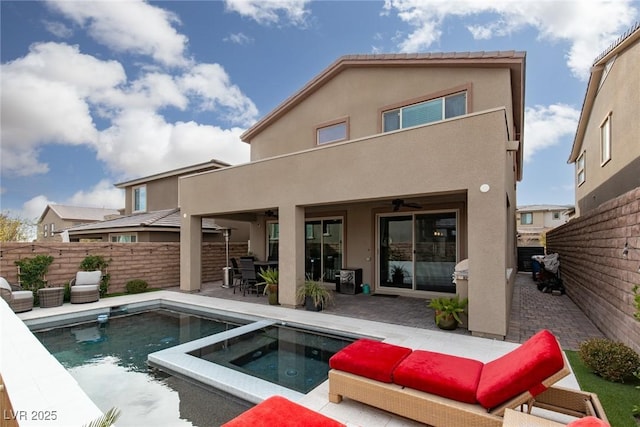 rear view of property with a patio, a balcony, a fenced backyard, ceiling fan, and stucco siding