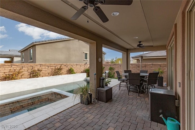 view of patio featuring a ceiling fan, outdoor dining space, and a fenced backyard