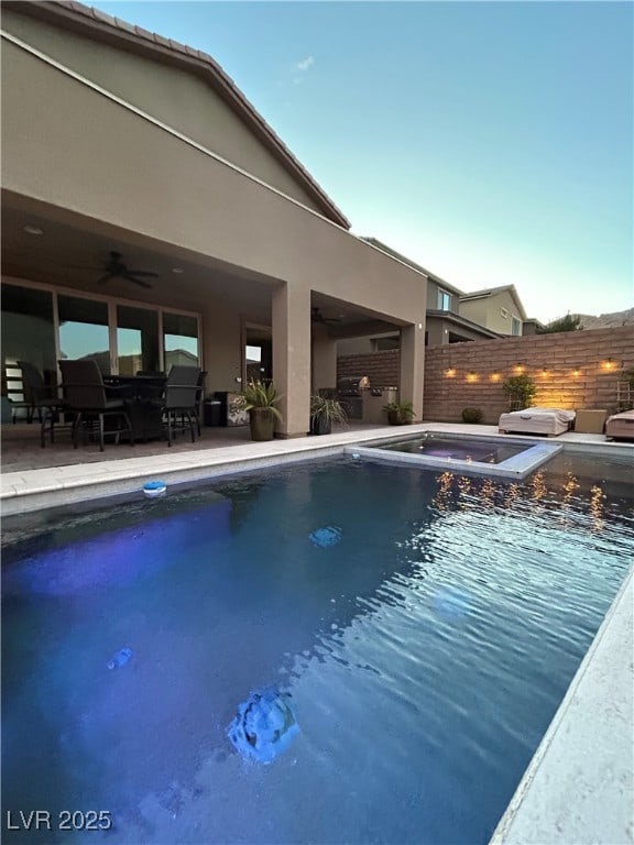 view of swimming pool with a ceiling fan, fence, a patio, and an in ground hot tub